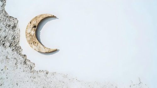 The image shows a crescent-shaped stone in a yellowish-brown color embedded on a rough white wall. The crescent is positioned towards the left side of the wall, where the wall surface appears eroded with a textured finish.