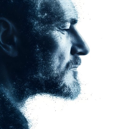 A portrait of a man with a white background, showing a complete side profile of his face. The image features a fragmented effect resembling scattered particles, creating an artistic visual effect. The contours highlight the prominent facial features, with a color gradient in shades of blue.