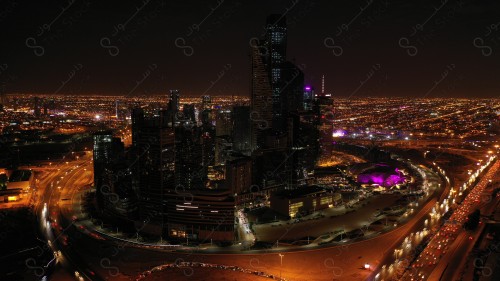 A shot showing the buildings and landmarks of the King Abdullah Financial District in the city of Riyadh, in front of it a group of residential houses with traffic.