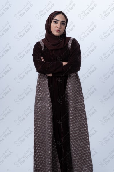 A young Saudi woman wearing an abaya and hijab, looking angry