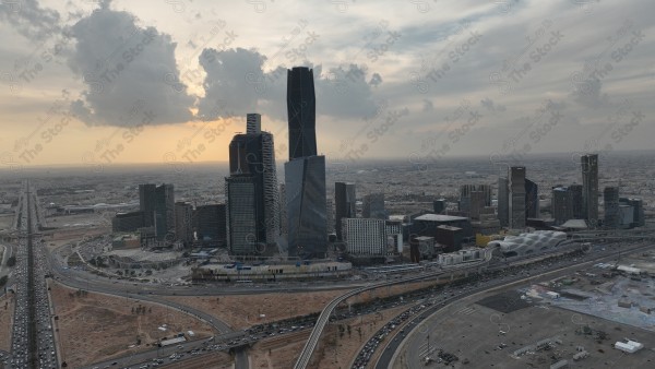 لقطة جوية للأبراج مركز الملك عبدالله المالي في العاصمة الرياض وتظهر السماء غائمة اثناء الغروب، حركة المرور في مدينة الرياض