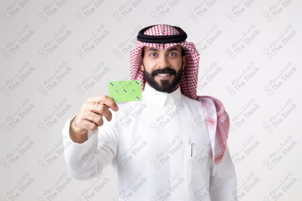 بورتريه رجل سعودي يحمل بطاقة خضراء على خلفية بيضاء