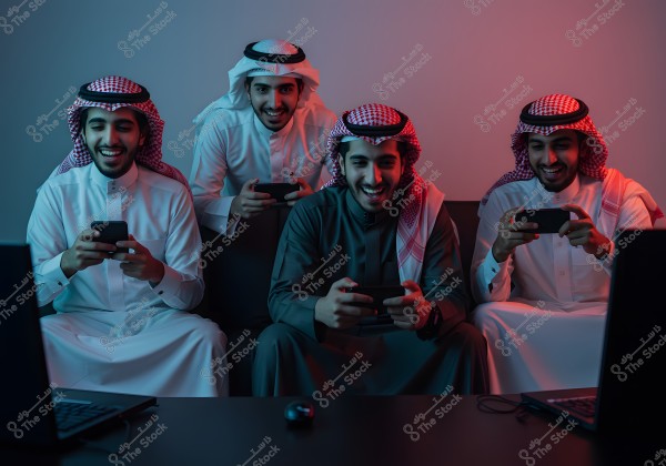 Four men sitting on a couch playing video games on mobile phones. They are wearing traditional Saudi attire with a ghutra, appearing to enjoy their time. The room is lit with blue and red lighting.