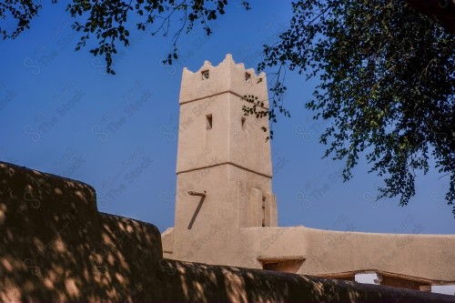 برج تراثي مبني من الطين في ساحة البجيري بالدرعية التاريخية وتظهر السماء صافية نهارًا