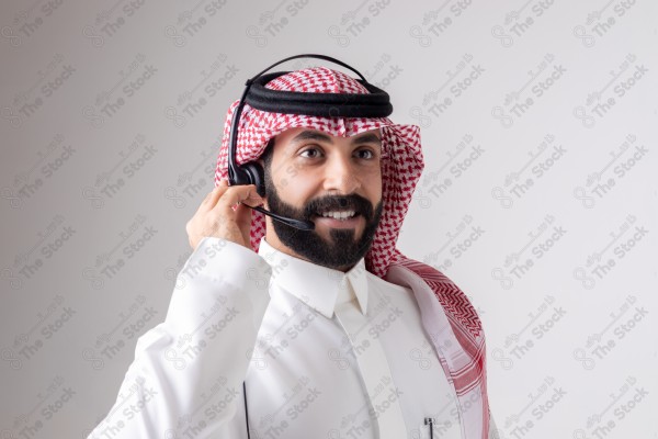 بورتريه رجل سعودي يلبس سماعة الرأس ويقوم بالتواصل عبر السماعة - خدمة العملاء ، مكالمة هاتفية