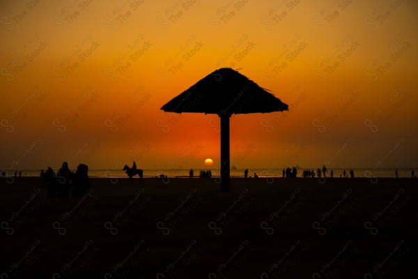 Silhouette people at beach against orange sky, From Jeddah, Saudi Arabia