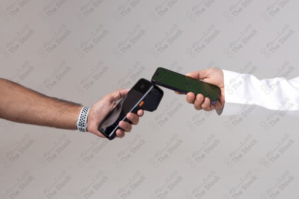 Portrait of a Saudi man holding a card and making automatic payments on a white background