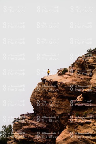 A man standing on the edge of a mountain contemplating the beauty of the beautiful nature of Asir