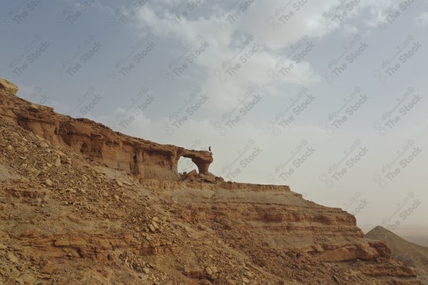 لقطة لجسر في جبال طويق بالسعودية بمنطقة الرياض وتظهر السماء غائمة نهارًأ, سلسلة من الجبال , جبال صحاري