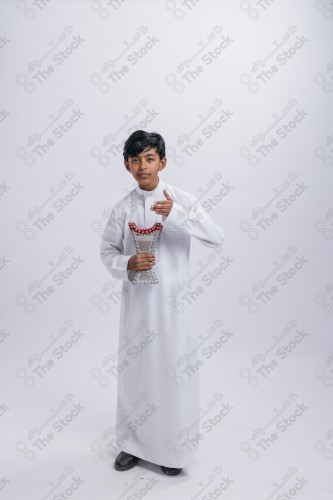 Portrait of a Saudi child on a white background making gestures with his hands while smiling, souvenir photos, ، documenting a happy moment, Eid candy, Eid gifts, Eidiyat, incense