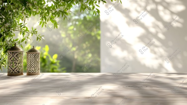 مشهد طبيعي يتضمن طاولة خشبية يظهر عليها فانوسان مزخرفان. تُحيط بهما أوراق شجر خضراء تتدلى من الأعلى, بينما تسمح الأشعة الشمسية بخلق ظلال جميلة على الطاولة والجدار الباهت في الخلفية.