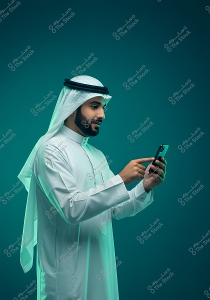 An image of a man wearing traditional Gulf attire, specifically a white thobe and a white keffiyeh with a black agal, using a smartphone. The background is a solid dark green, highlighting the focus on the individual and the phone.