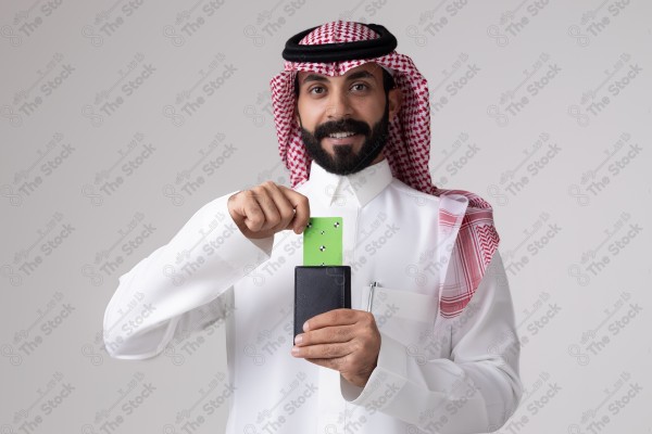 بورتريه رجل سعودي يحمل بطاقة خضراء على خلفية بيضاء