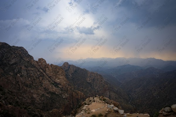 لقطة لسلسلة من الجبال الصخرية والطرق الوعرة الممتده بالجبل في مدينة الطائف وتظهر السماء ملبدة بالغيوم غرب السعودية، سلسلة من الجبال الصخرية، الطبيعة بالسعودية.