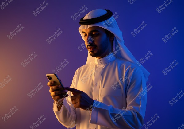 A portrait of a man wearing a traditional white thobe and headscarf, using a smartphone in his hand, set against a blue and orange colored background. The scene suggests the use of technology in everyday life.