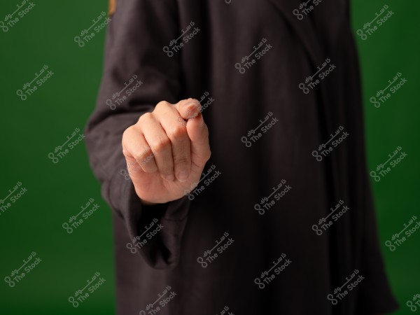 يد تشير إلى الأمام بخلفية خضراء.