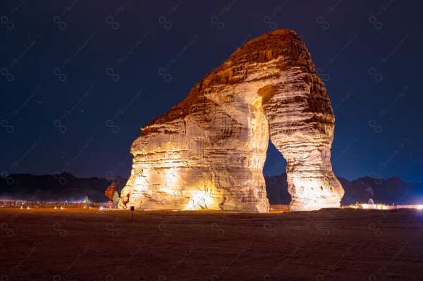 An aesthetic shot of Elephant Mountain in the middle of the desert in AlUla, showing the almost clear sky at night. Tourism in AlUla.