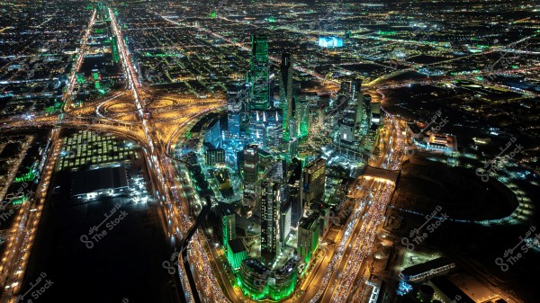 ** لقطة جوية لمدينة مضاءة ليلاً, تُظهر العديد من ناطحات السحاب الحديثة ومشاهد مرور مزدحمة. الأضواء الساطعة تضيء المدينة والمناظر المصاحبة للطرق السريعة.\r\n\r\n**