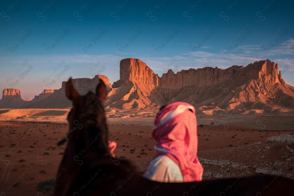 فارس سعودي يمتطي الخيل بالصحراء ومن خلفه تظهر الجبال صباحا،  ترويض الخيل، مدرب الخيول ، الخيل العربي الأصيل ، هواية ركوب الخيل ،فعاليات لركوب الخيل