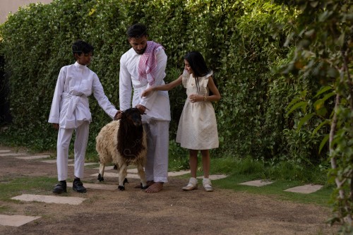 A Saudi family gathered in the eid , the eid sheep, the sacrifice, aodhiyah, the eid , visits and the family gathering, the customs of the eid in the Saudi society, a happy family atmosphere, eid and occasions.