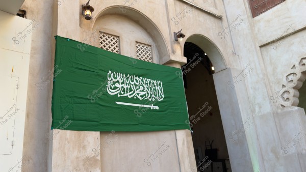 العلم السعودي معلق على مبنى طيني