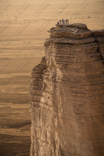 لقطة جوية لجبل من جبال طويق المسمى بحافة العالم في السعودية وتظهر السماء صافية. سلسلة من الجبال الصخرية، غروب الشمس