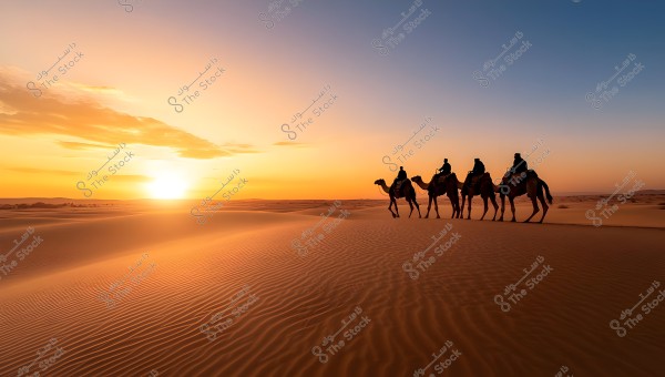 Image of a desert scene at sunset. Five camels are led in a line across the sand, with a person sitting on each camel. The sand ripples in the foreground, and the sky glows with orange and golden hues, with a few clouds decorating the horizon.