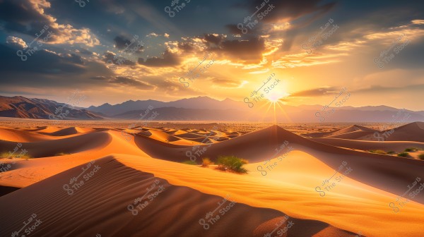 A scenic view of a desert landscape under a bright sun and a sunset scene. The wavy golden sand dunes are in the foreground, while mountains are visible in the distant horizon. The sky is colored with gradients of orange and blue, with some scattered clouds.
