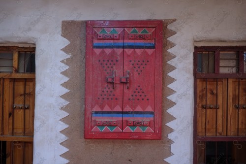 Detail of an old wooden window in a mud wall, decorative wooden window.