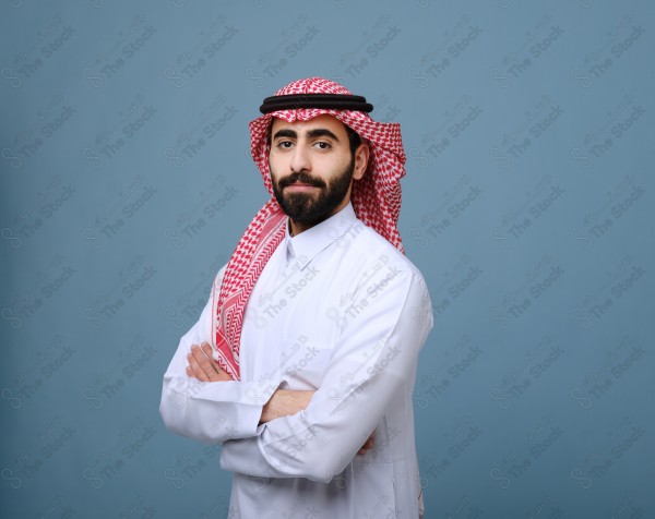 Portrait of a Saudi young man wearing the Saudi dress, and happiness and joy appearing on his features, against a heavenly background