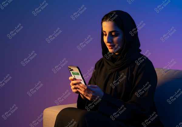 A portrait of a woman sitting on a couch, wearing a black abaya and hijab. She is looking at a smartphone in her hand. The background is softly lit with calming blue and purple hues, creating a warm and relaxed ambiance.