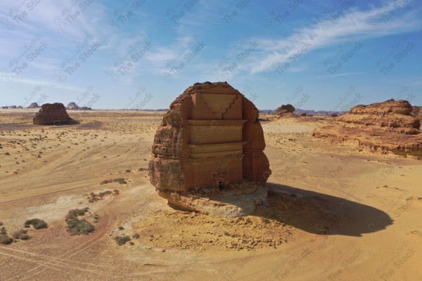 An aerial shot of Al-Farid Palace in Al-Ula Governorate, houses carved into the mountains, Mada’in Saleh, a series of rocky mountains, tourism in Saudi Arabia.