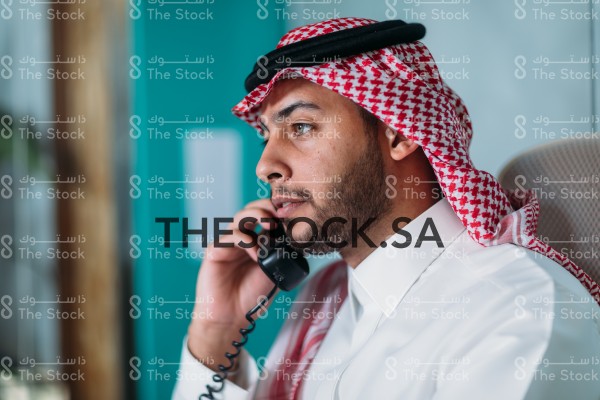 موظف سعودي يتحدث عبر الهاتف في مكتبه