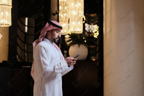 شاب سعودي في استقبال فندق ويقوم بتفاعلات متعددة ، ويظهر بيده حقيبة السفر