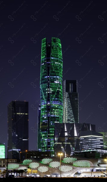 A shot showing the buildings and landmarks of the King Abdullah Financial Center in Riyadh lit up in green to celebrate National Day, and the sky appears clear. National Day, buildings and landmarks.