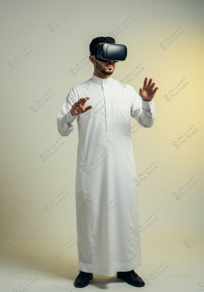 Image of a man wearing a virtual reality headset standing in an interactive pose. The man is dressed in traditional white clothing against a neutral background. His expression suggests interaction with unseen digital content.