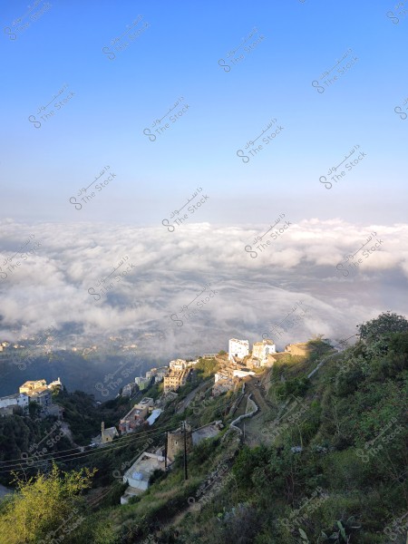 منظر خلاب لمدينة تقع على قمة جبل, تحيط بها الغيوم الكثيفة تحت سماء زرقاء صافية. المباني موزعة على سفوح الجبال الخضراء, مما يعكس الدمج بين الطبيعة والعمران.