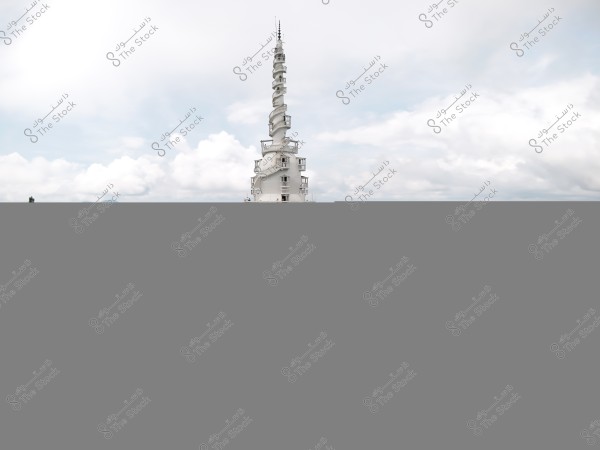 The image shows a tall white tower with a circular base, resembling either a lighthouse or an observation tower, surrounded by green forests and mountainous landscapes in the background. The sky is filled with clouds, adding a dramatic effect to the scene.