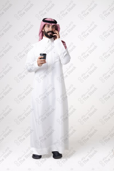 Portrait of a Saudi man holding a phone and a cup of coffee and making a phone call with different expressions