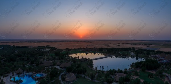 لقطة جوية جمالية لبحيرة وسط الصحراء السعودية ، الطبيعة الصحراوية ، جمال الطبيعة بالسعودية اثناء غروب الشمس .