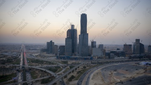 An aerial shot of the towers of the King Abdullah Financial District, showing the buildings and landmarks of the city of Riyadh in the daytime at sunset.