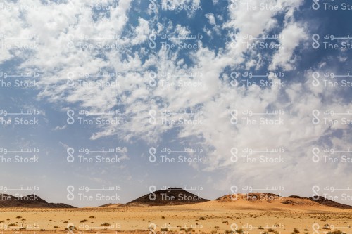 السماء الزرقاء و الغيوم المتقطعة في صحراء منطقة الجوف شمال المملكة العربية السعودية