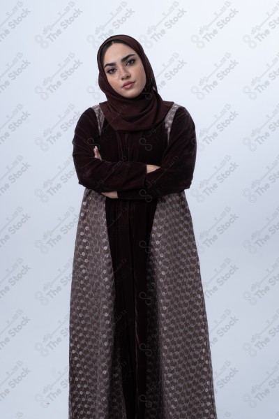 A young Saudi woman wearing an abaya and hijab, looking angry