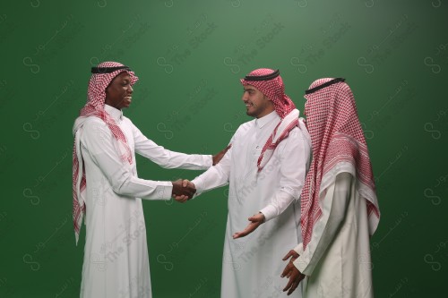 شاب سعودي يرتدي الزي السعودي التقليدي يصافح ضيوفه في إحدى المناسبات