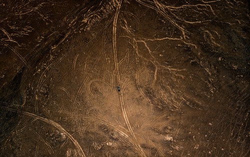 Overhead shot of a car in the middle of the desert, nature in Saudi Arabia