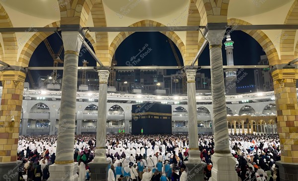 View of the Kaaba surrounded by crowds of people praying in the Grand Mosque in Mecca.