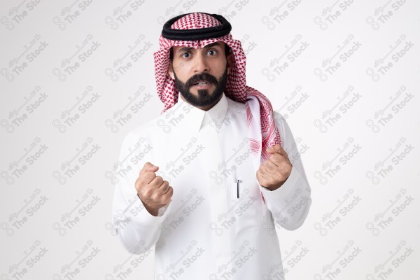 بورتريه رجل سعودي يقف على خلفية بيضاء ويعبر عن غضبة