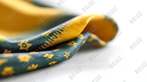 Close-up image of a folded fabric with a yellow and orange floral design on a dark green background. The image highlights the texture of the fabric and the small star patterns clearly visible on its surface.