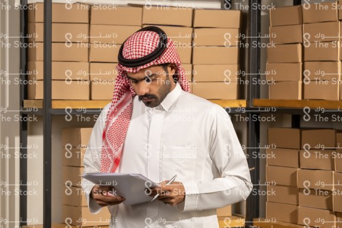 موظف سعودي يراجع مخزون المستودع