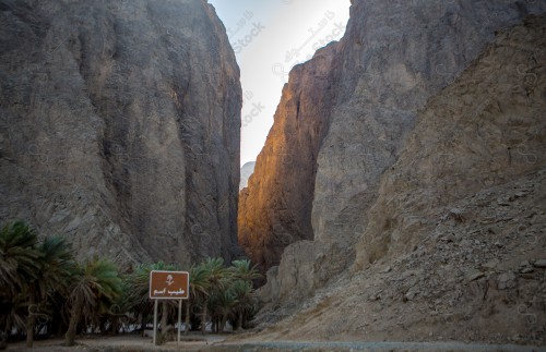 صورة لجبال طيب اسم في شمال مقنا غرب مدينة البدع في السعودية ، الجبال والتكوينات الصخرية في تبوك شمال المملكة العربية السعودية ، جمال اشجار النخيل على مدخل الجبل.